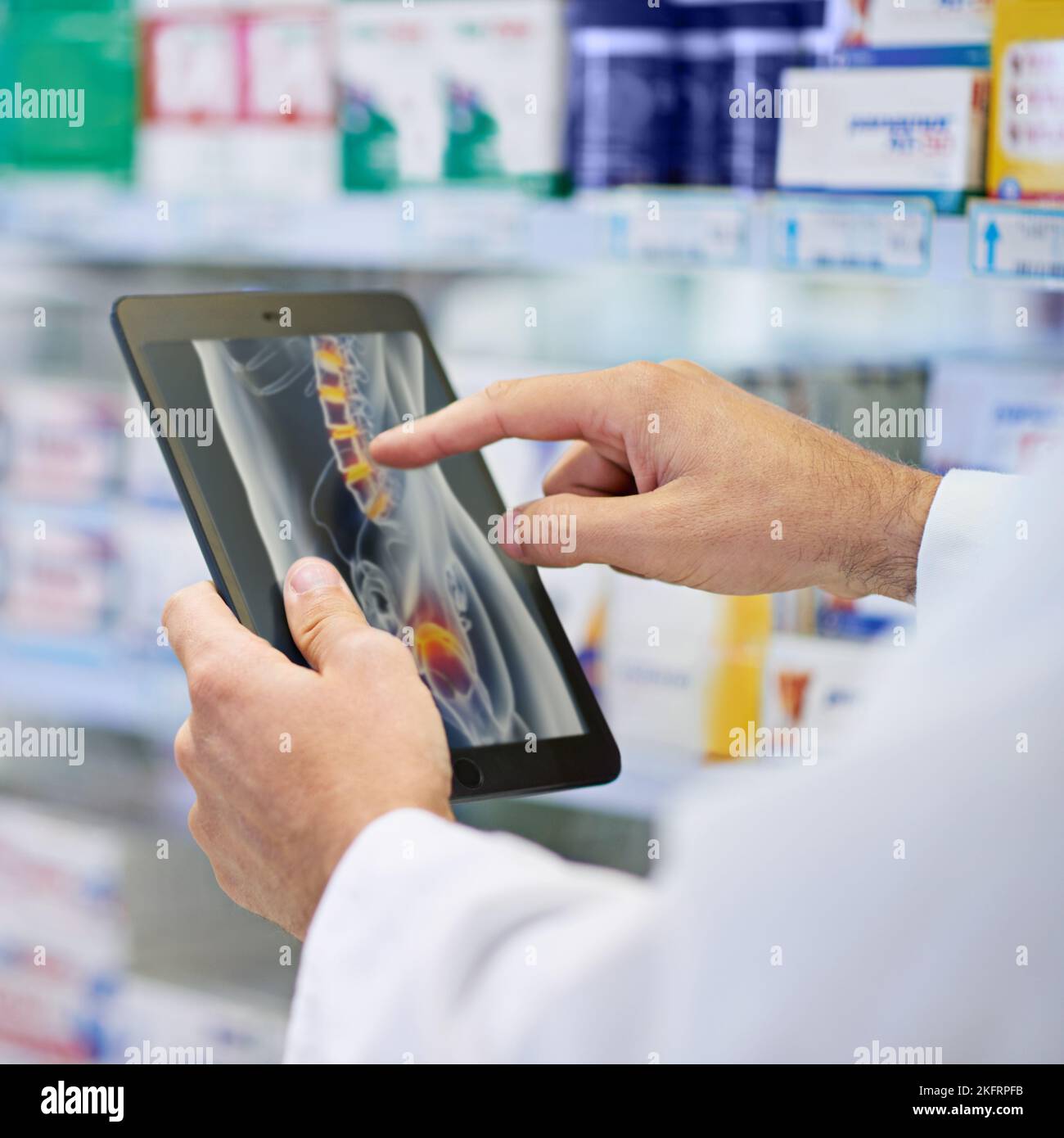 Recherche de conseils en ligne. Un pharmacien travaillant sur une tablette numérique. Banque D'Images