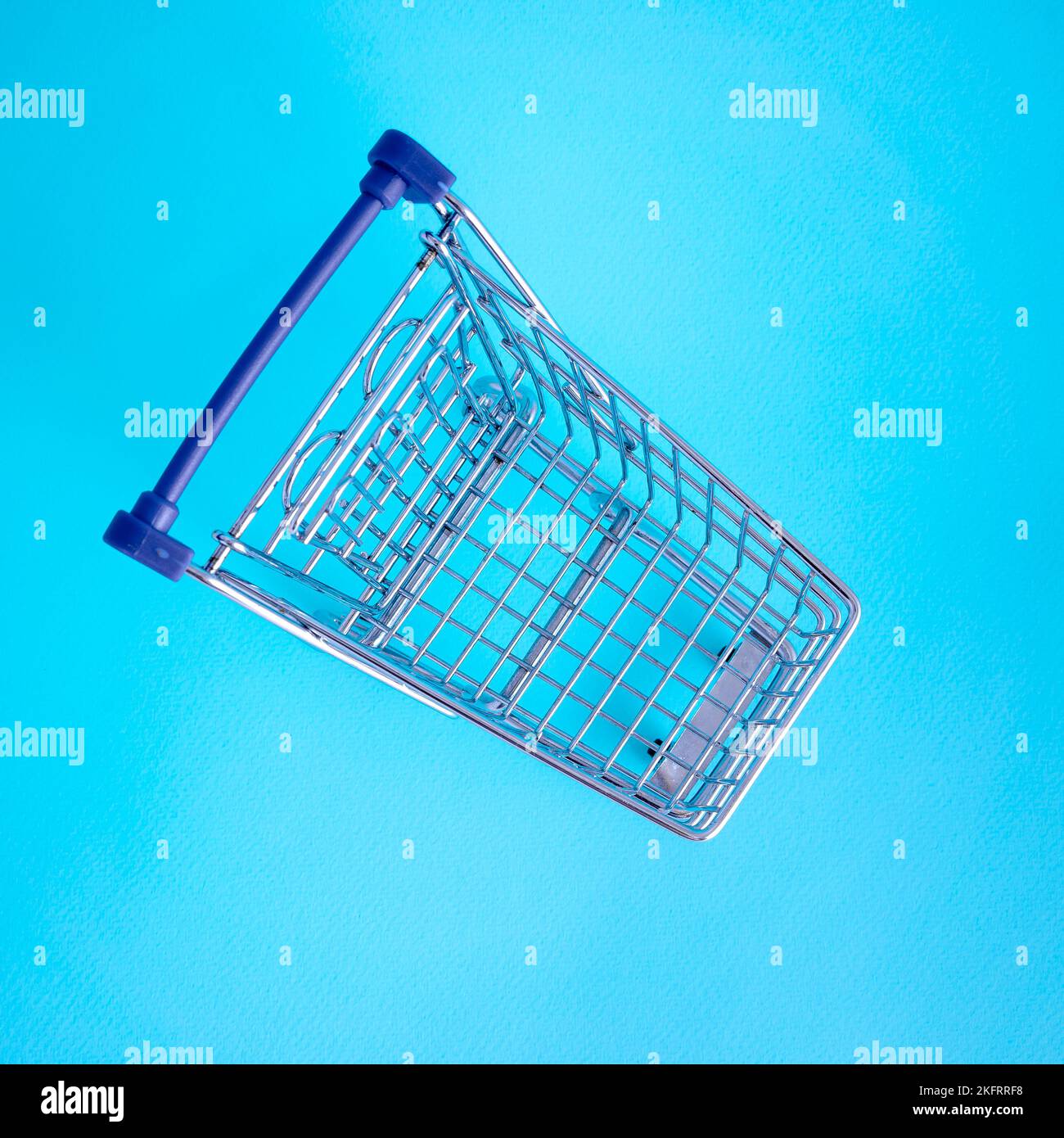 vider le panier sur fond de couleur, mini chariot métallique isolé sur fond de couleur Banque D'Images