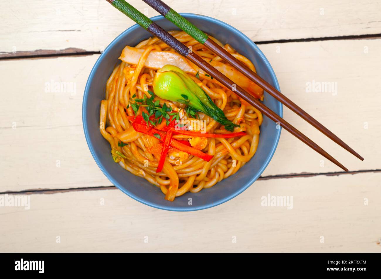 A la main tiré les nouilles ramen chinoises étirées sur un bol avec un bâton de broyeur Banque D'Images