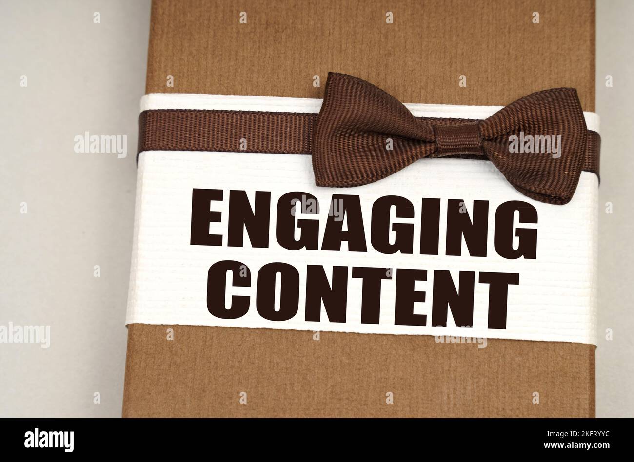 Concept financier et commercial. Sur la boîte d'emballage avec un noeud papillon l'inscription - contenu engageant Banque D'Images