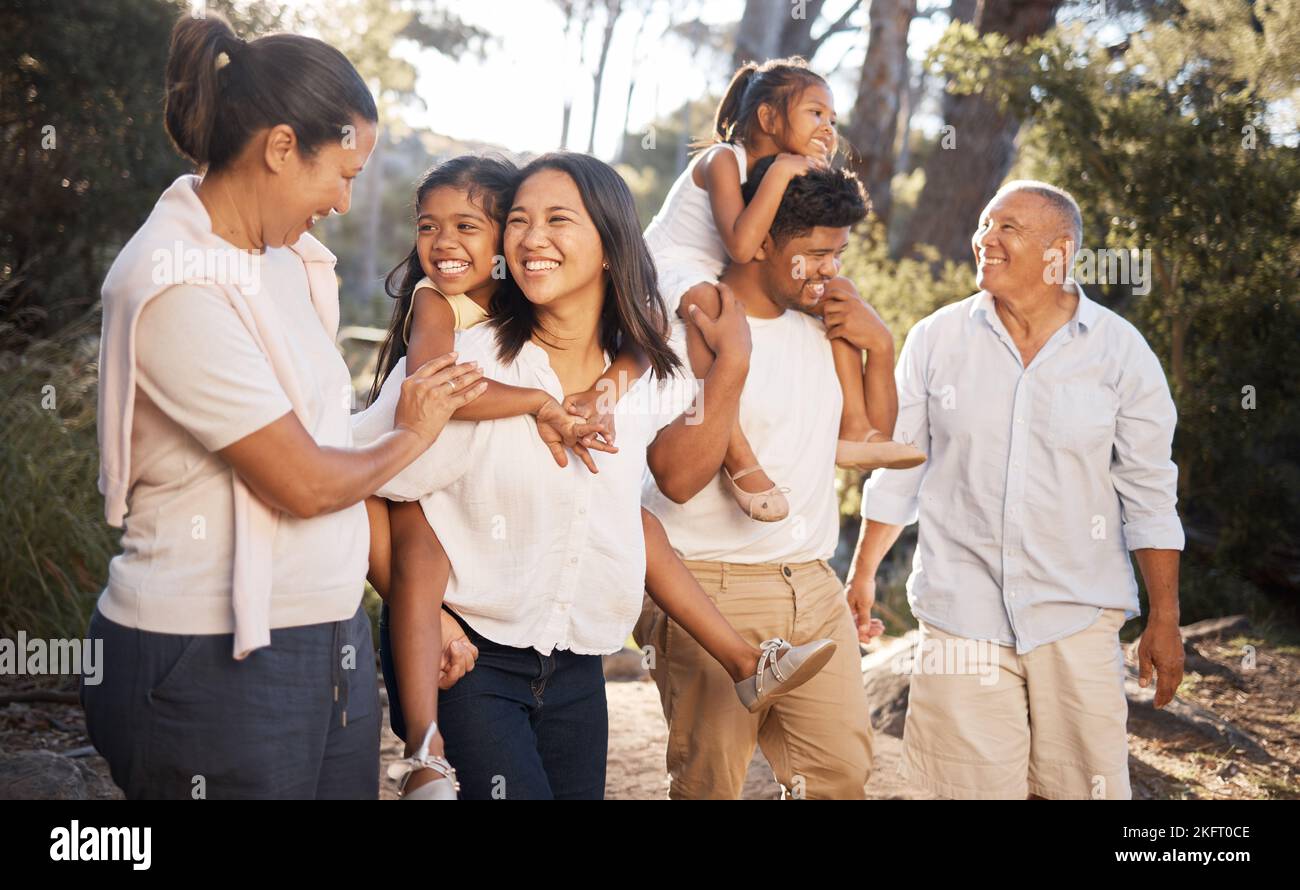 Grande famille marchant dans le parc, l'été et la liberté ensemble en plein air frais. Famille, parents et grands-parents heureux dans le jardin avec les enfants enthousiastes à Banque D'Images
