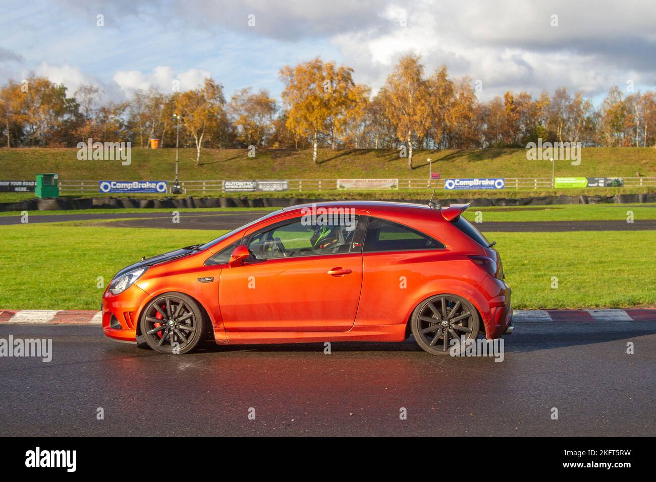 2012 Orange Vauxhall Corsa VXR Nurburgring Edition 1,6T 205 conduite dans des virages difficiles à grande vitesse et à faible vitesse du circuit trois sœurs près de Wigan, Royaume-Uni Banque D'Images