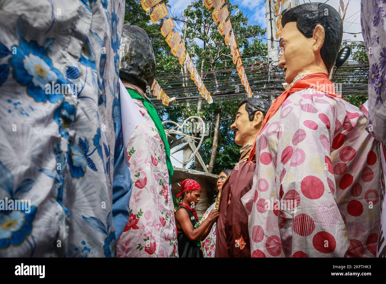 Angono, Philippines, 20/11/2022, Un homme a vu s'habiller une statue de paper-mache pendant le grand défilé du festival de Higantes. Les habitants célèbrent le festival de leur ville pour la première fois après deux ans de suspension en raison de la pandémie. Les géants du boson de Higantes ou du papier-maché auraient d'abord été fabriqués par les agriculteurs locaux comme une forme de protestation contre leurs propriétaires terriens durant l'ère de la colonisation espagnole. Les marionnettes géantes papier-maché mesurent de quatre à cinq pieds de diamètre et de dix à douze pieds de hauteur et ne peuvent contrôler les géants que de l'intérieur d'eux. Banque D'Images