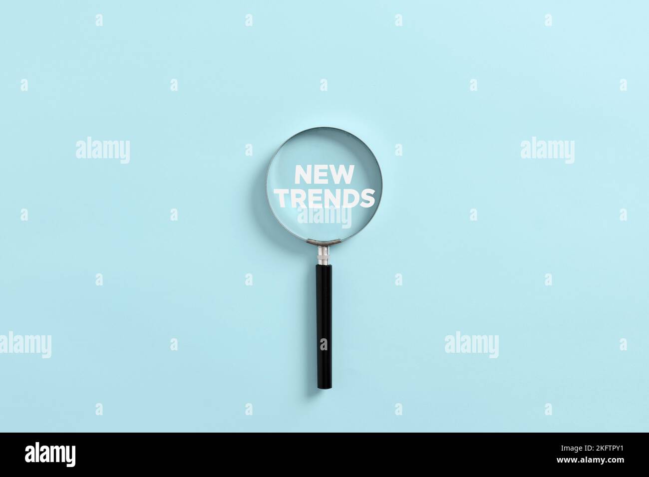 La loupe agrandit le mot nouvelles tendances. Analyse ou recherche du nouveau concept de tendances. Banque D'Images