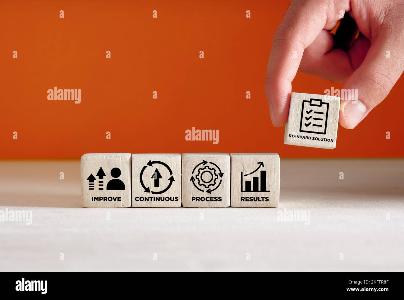 Concept Kaizen. Amélioration continue de la qualité et standardisation dans les affaires pour l'efficacité et l'efficience. Hand place les icônes du cycle Kaizen sur la woode Banque D'Images