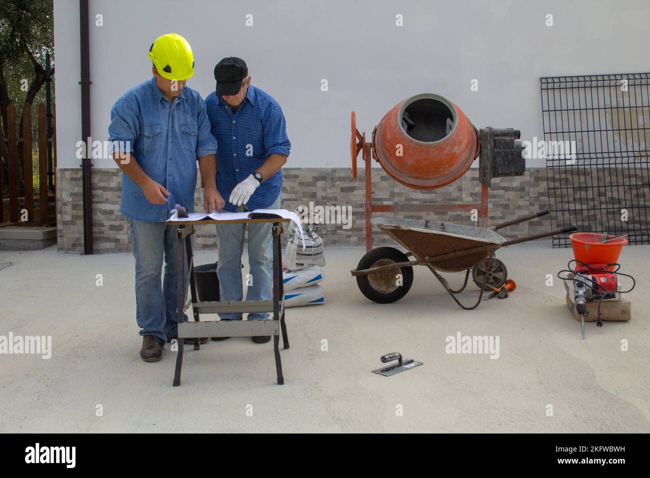 Image d'un ingénieur et d'un travailleur de la construction sur un chantier de construction lorsqu'ils consultent le plan du projet à mettre en œuvre. Banque D'Images
