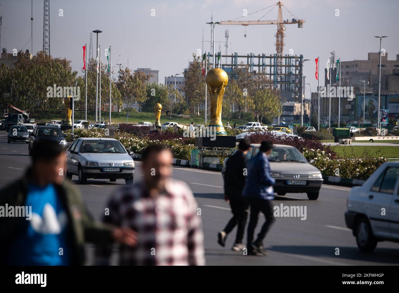 Deux hommes marchent devant une sculpture du trophée de la coupe du monde de la FIFA sur la place Azadi (liberté) à l'ouest de Téhéran. L'Iran joue l'Angleterre dans son premier match de la coupe du monde de la FIFA Qatar 2022 sur 21 novembre avant de faire face au pays de Galles et aux États-Unis dans le groupe B. (photo de Sobhan Farajvan / Pacific Press/Sipa USA) Banque D'Images