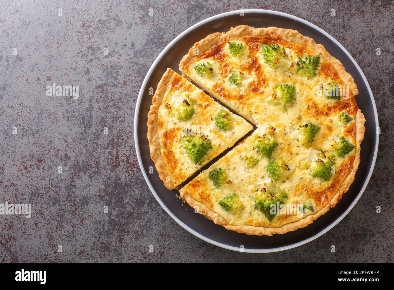 Quiche de légumes cuite au brocoli romanesco, œufs et fromage en gros plan dans une assiette sur la table. Vue horizontale du dessus Banque D'Images