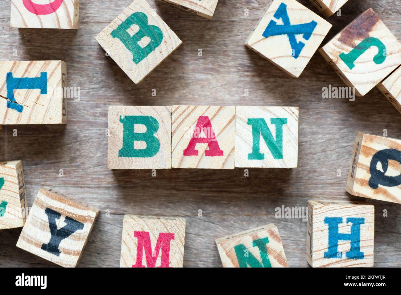 Bloc de lettres de l'alphabet dans le mot Ban et une autre lettre sur fond de bois Banque D'Images