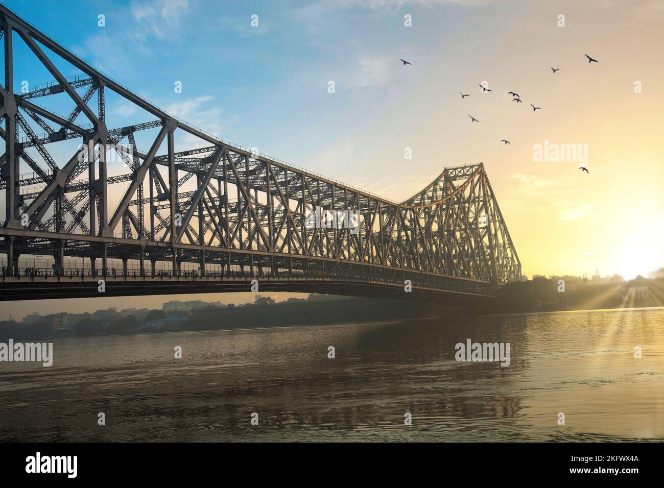Pont Howrah au lever du soleil. Un célèbre pont en porte-à-faux construit sur la rivière Ganges qui relie la ville de Kolkata au quartier de Howrah. Banque D'Images