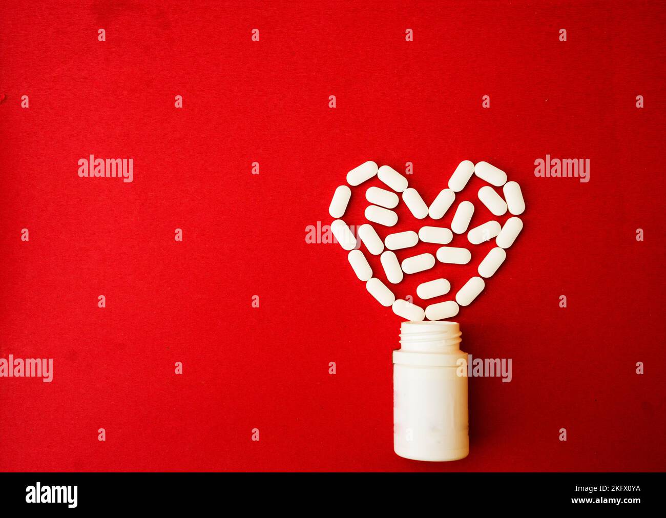 Les pilules débordent de la bouteille de pilule et isolées sur le rouge.Vue de dessus avec espace de copie.Concept de médecine Banque D'Images