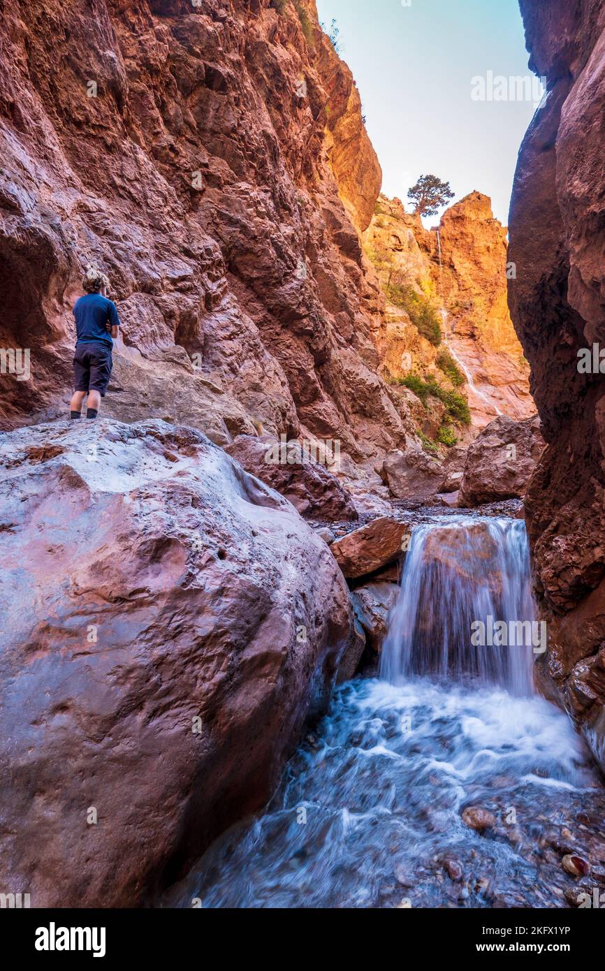 Trekker mâle dans une gorge étroite du massif m'Goun des montagnes de l'Atlas marocain Banque D'Images