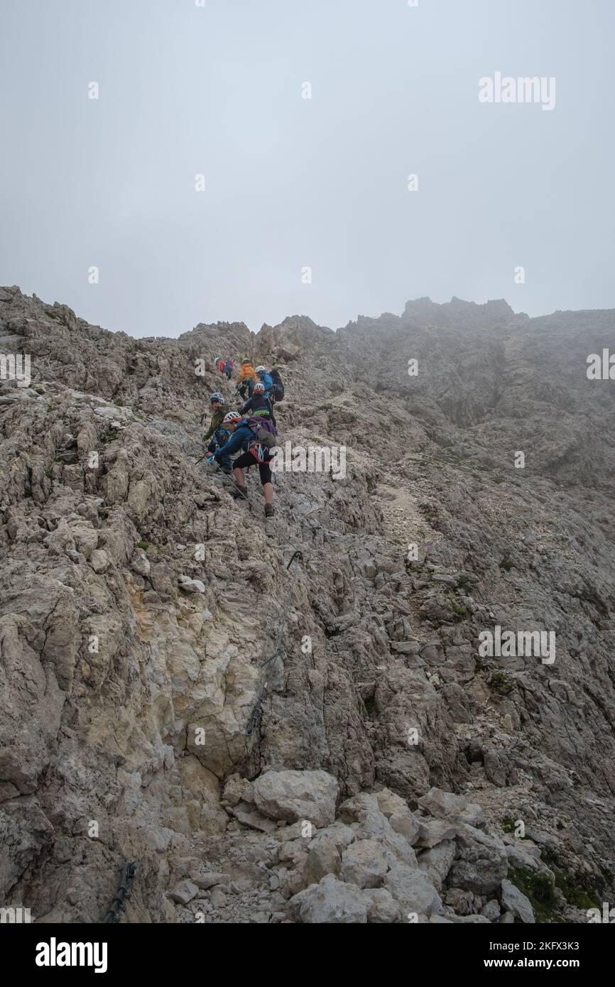 Plusieurs grimpeurs grimpant sur le rocher de la via ferrate de la montagne Rotwand dans les Dolomites italiens. Banque D'Images