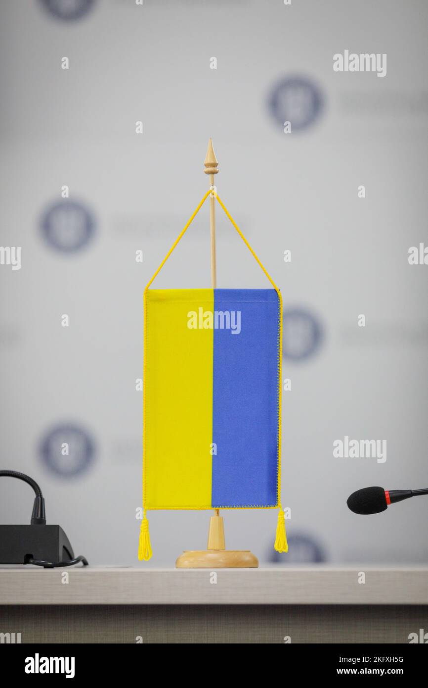 Détails de faible profondeur de champ (mise au point sélective) avec un drapeau ukrainien lors d'une conférence de presse. Banque D'Images