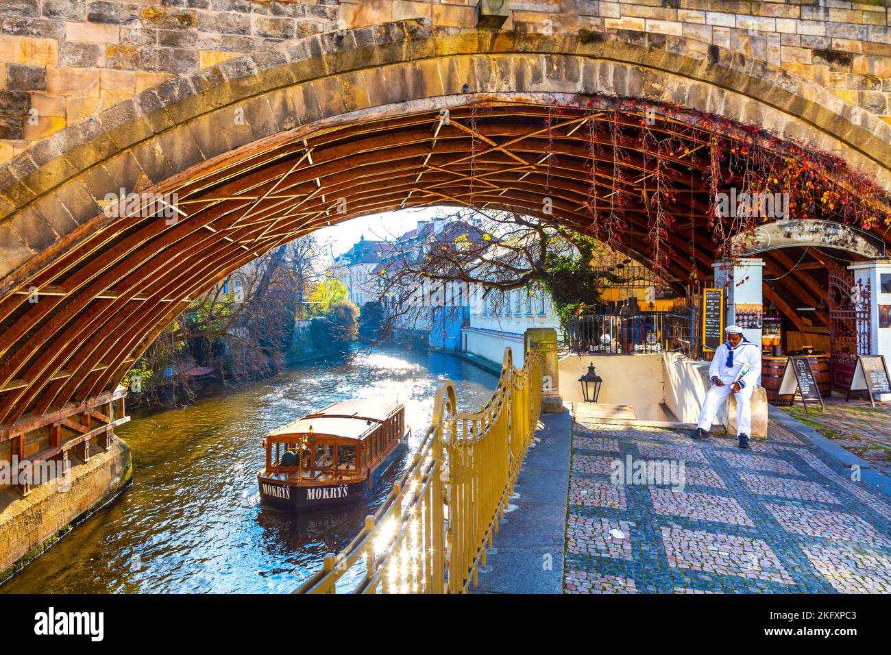 Arche du pont Charles et bateau de croisière sur le canal de Čertovka, Prague, République tchèque Banque D'Images