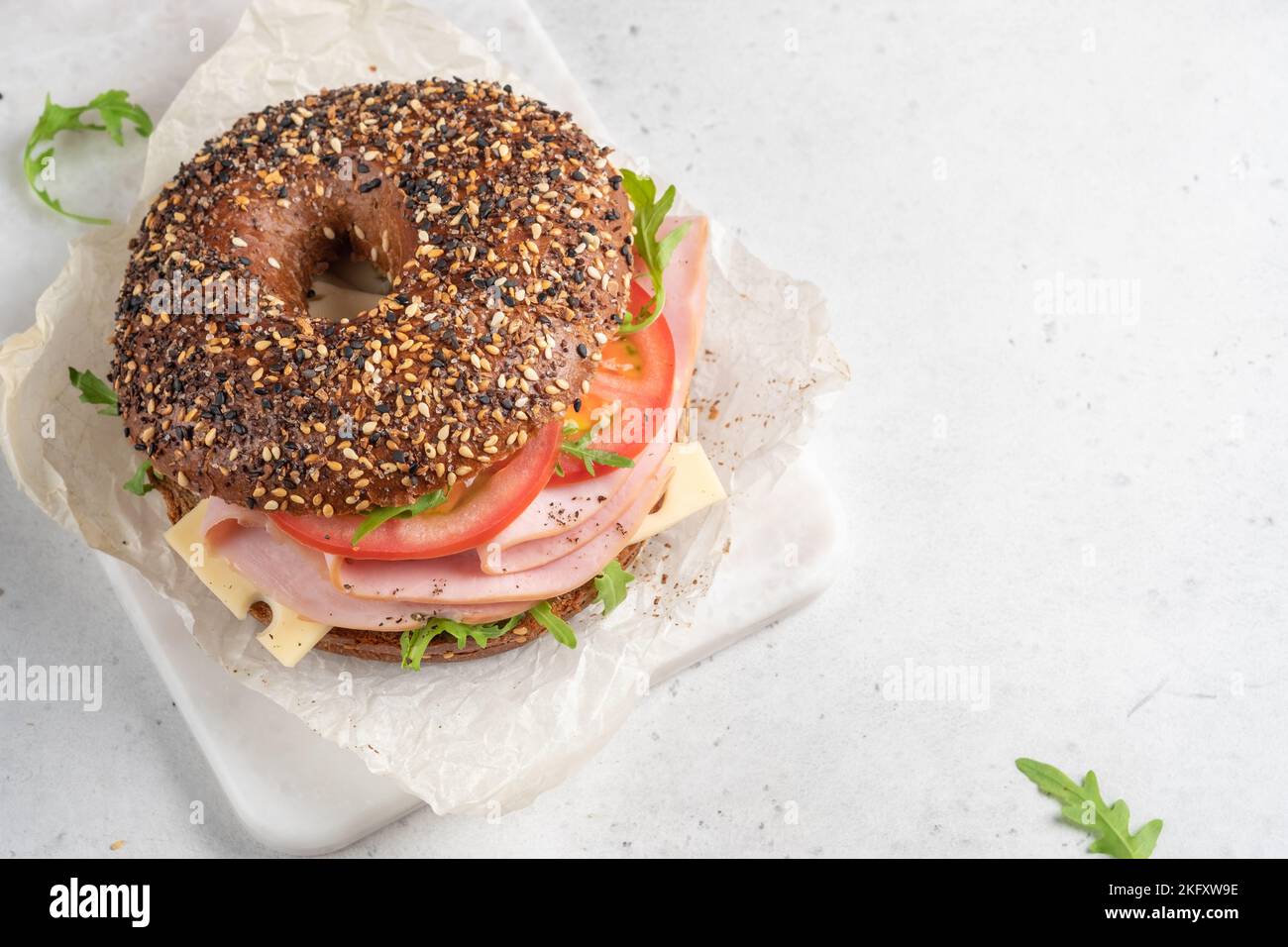 bagel rempli de roquette, de jambon de dinde, de fromage à la crème et de tomate Banque D'Images