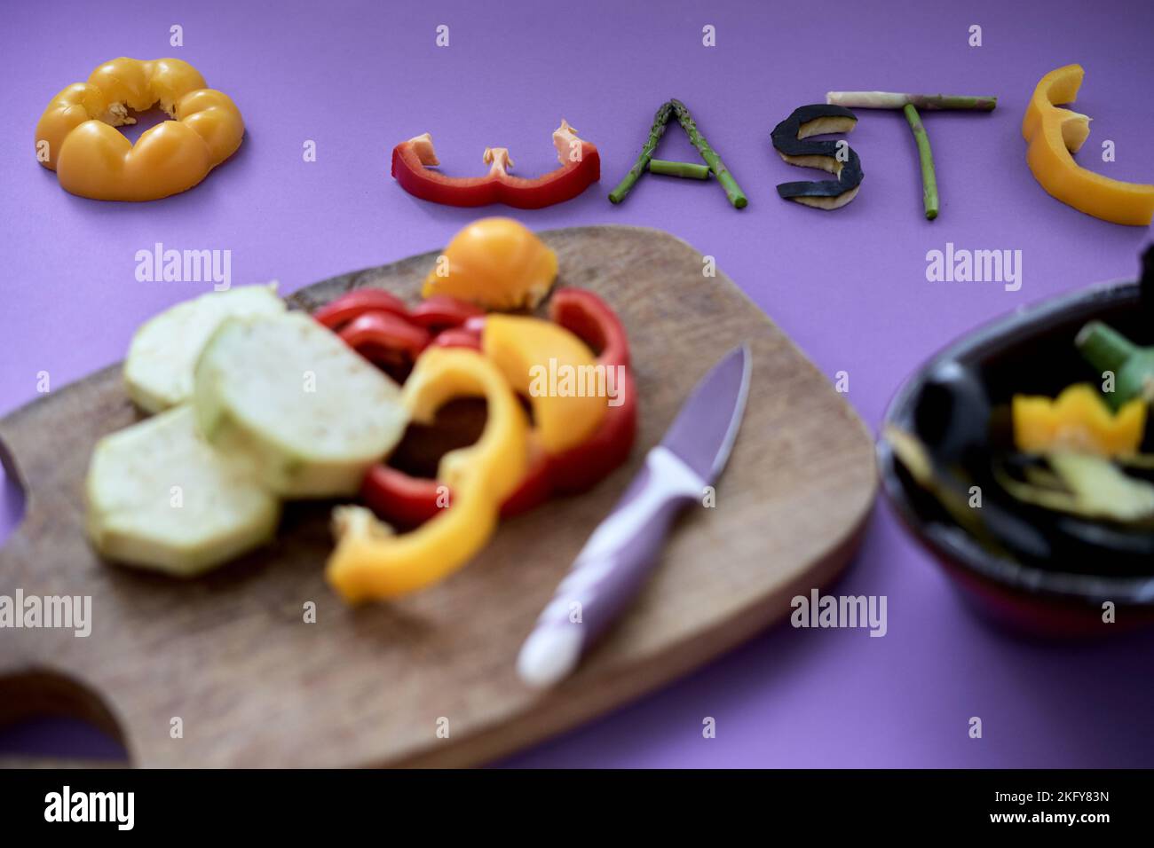 formation du mot zéro déchet avec des morceaux de vegatal à côté d'une planche en bois et un récipient plein de légumes Banque D'Images