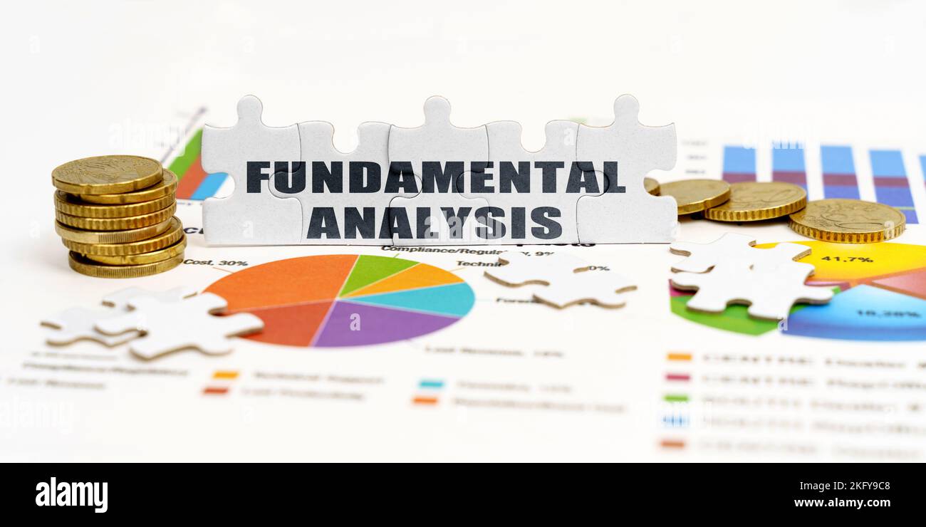 Affaires et économie. Il y a des pièces de monnaie et des puzzles sur les tableaux financiers avec l'inscription - ANALYSE FONDAMENTALE Banque D'Images