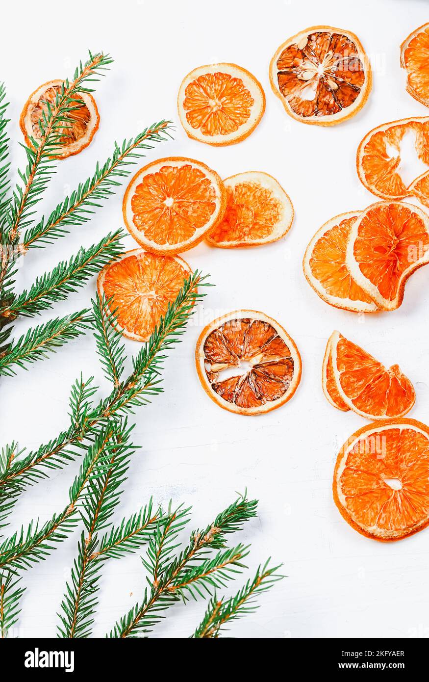 Arrière-plan de Noël. Branches d'oranges et d'épinette séchées. Nouveau contexte minimaliste de l'année 2023 Banque D'Images
