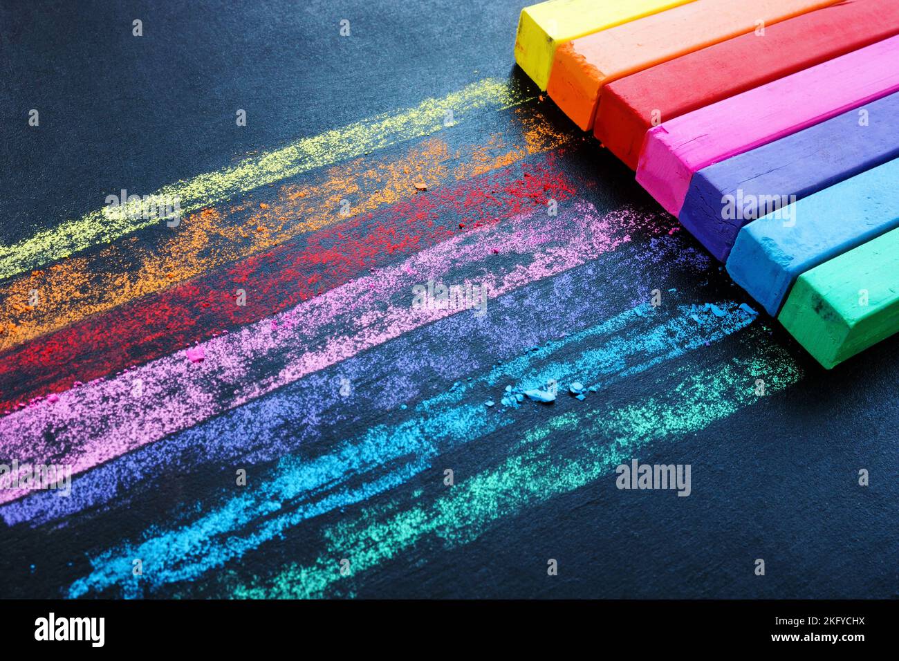 Des crayons multicolores sur un tableau noir comme symbole de créativité. Arrière-plan coloré. Banque D'Images