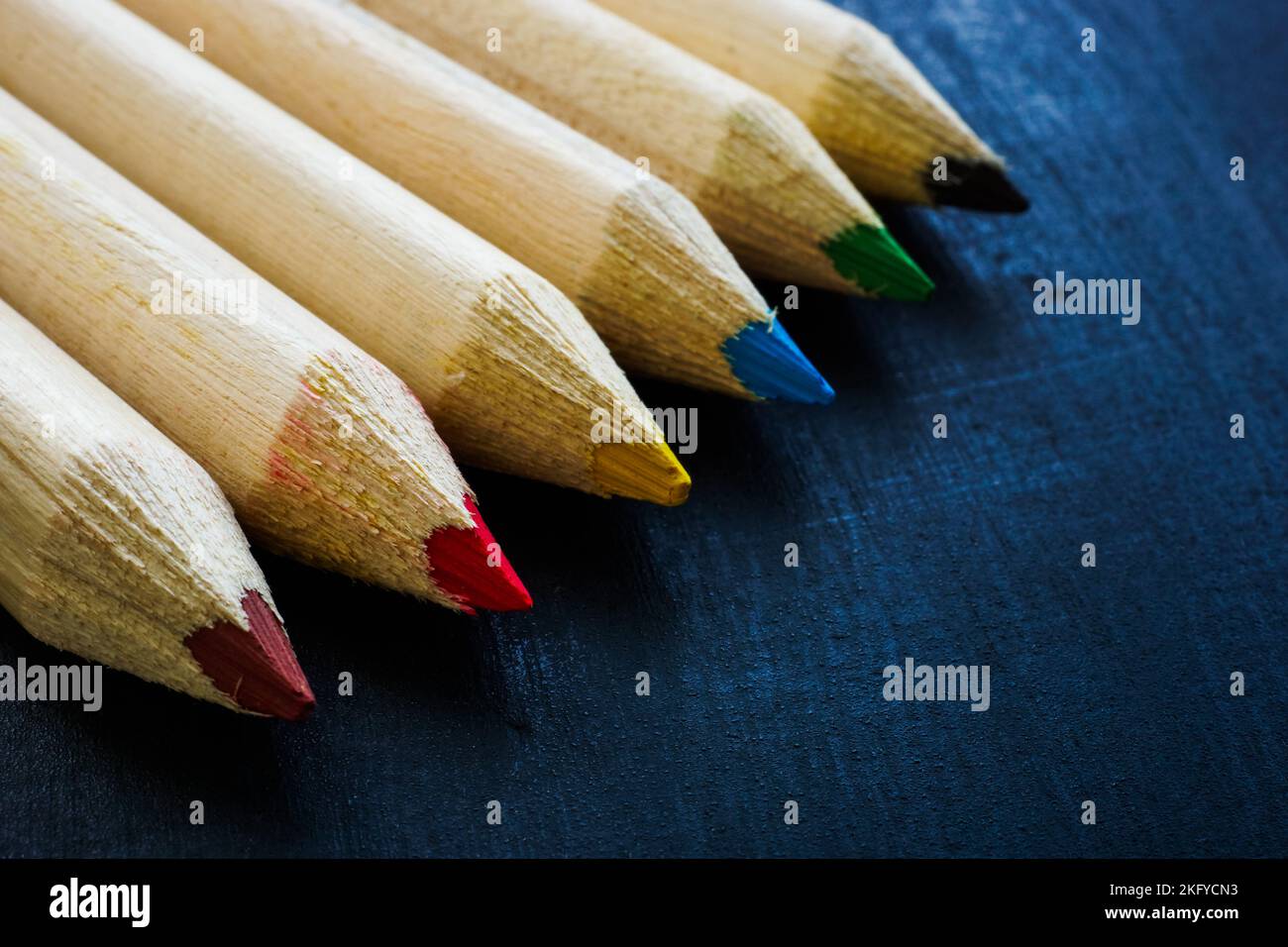 Crayons de couleur sur une surface sombre comme symbole de nouvelles idées, de l'art et de l'artisanat. Banque D'Images