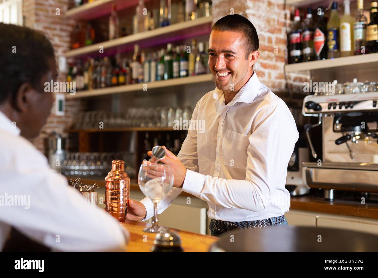 Un barkeeper servant les visiteurs au bar Banque D'Images