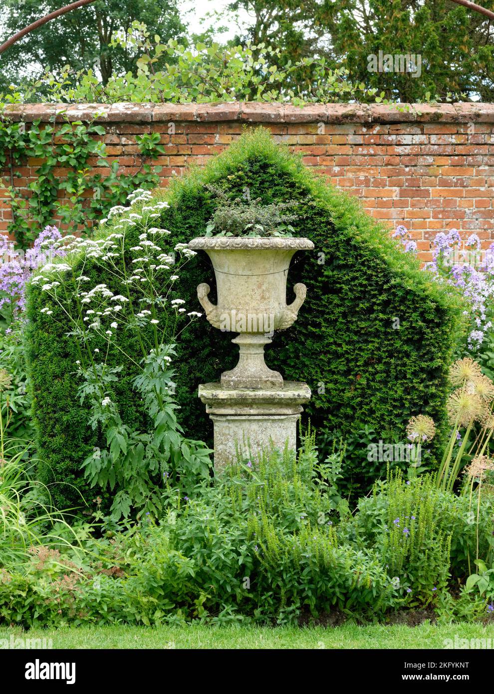 Été Portrait de vue sur le jardin clos avec urne ornée et haie dans le Helmingham Hall et les jardins du Suffolk Banque D'Images