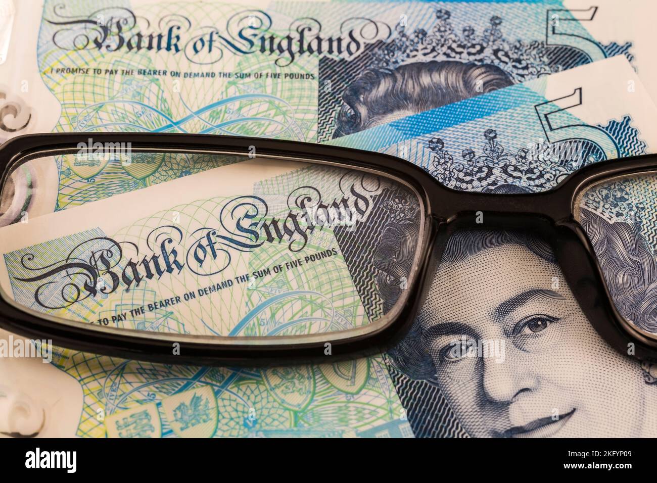 Portrait de la reine Elizabeth II sur la Banque d'Angleterre cinq livre note à travers des lunettes de lecture noires. Banque D'Images