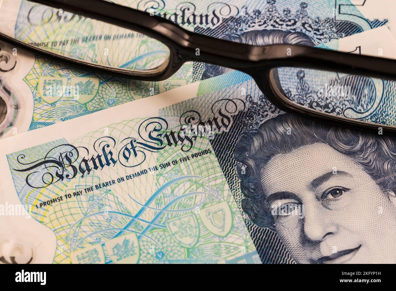 Portrait de la reine Elizabeth II sur la Banque d'Angleterre cinq livre note à travers des lunettes de lecture noires. Banque D'Images