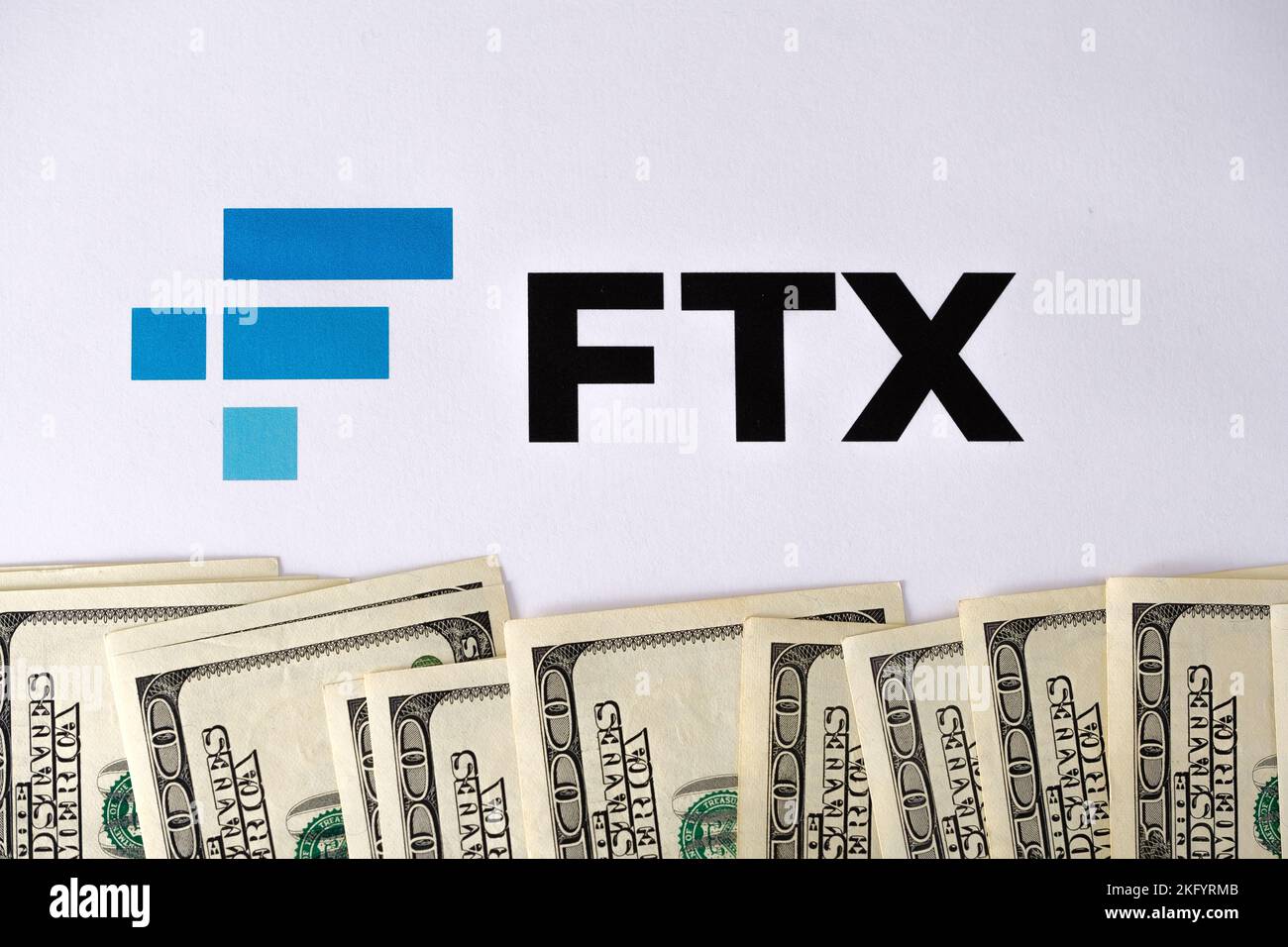Le logo FTX crypto-monnaie est imprimé sur le papier et les billets en dollars américains qui l'entourent. Concept de faillite et de dette d'entreprise. Stafford, Royaume-Uni Banque D'Images