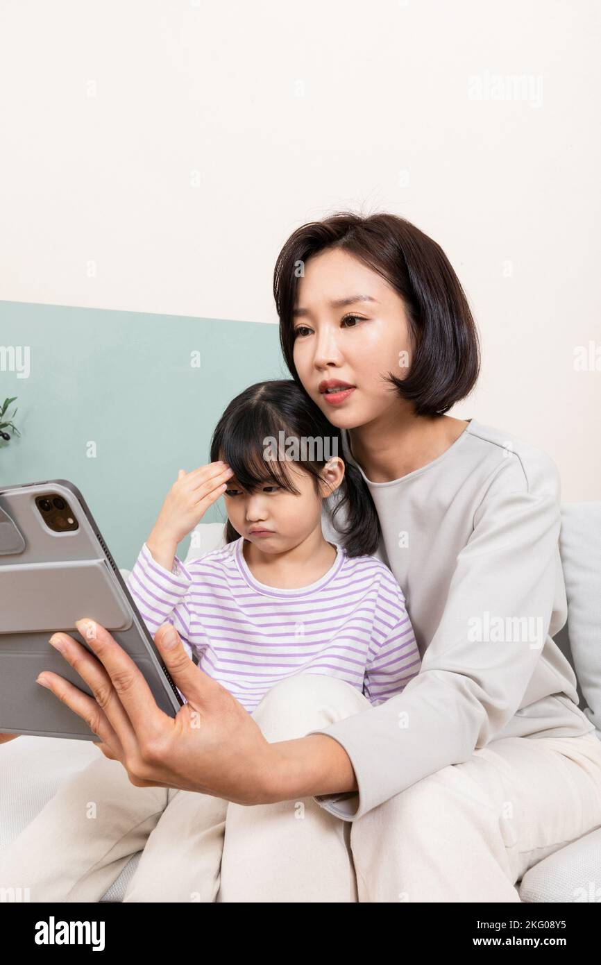 Enfant et maman coréens utilisant une tablette, concept de consultations médicales en ligne Banque D'Images