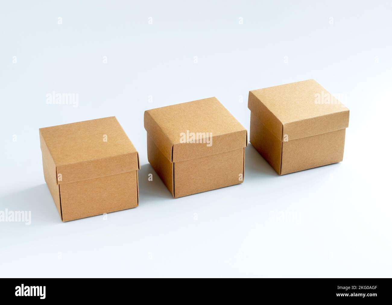 Trois boîtes en carton isolées sur fond blanc. Boîte cadeau en carton. Boîte  en papier kraft carrée avec couvercle sur le dessus. Livraison, colis,  emballage avec s en ligne Photo Stock -