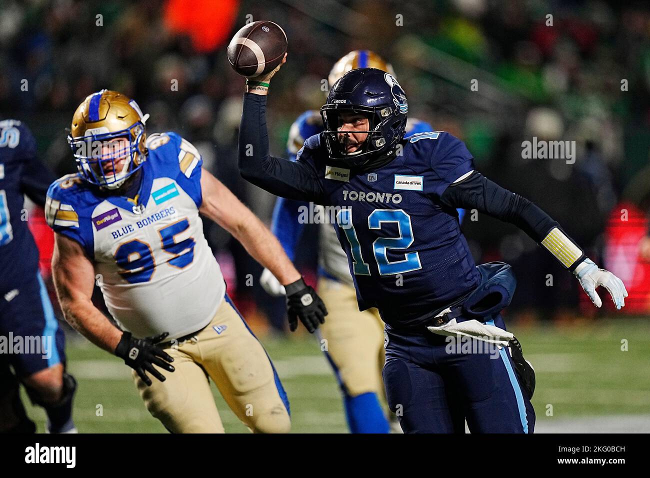 Toronto Argonauts Quarterback Chad Kelly (12) court pour le yardage passé Winnipeg Blue Bombers défensive attach Jake Thomas (95) pendant la deuxième moitié de l'action à la coupe Grey 109th au stade Mosaic à Regina, le dimanche 20 novembre 2022. LA PRESSE CANADIENNE/Jonathan Hayward Banque D'Images
