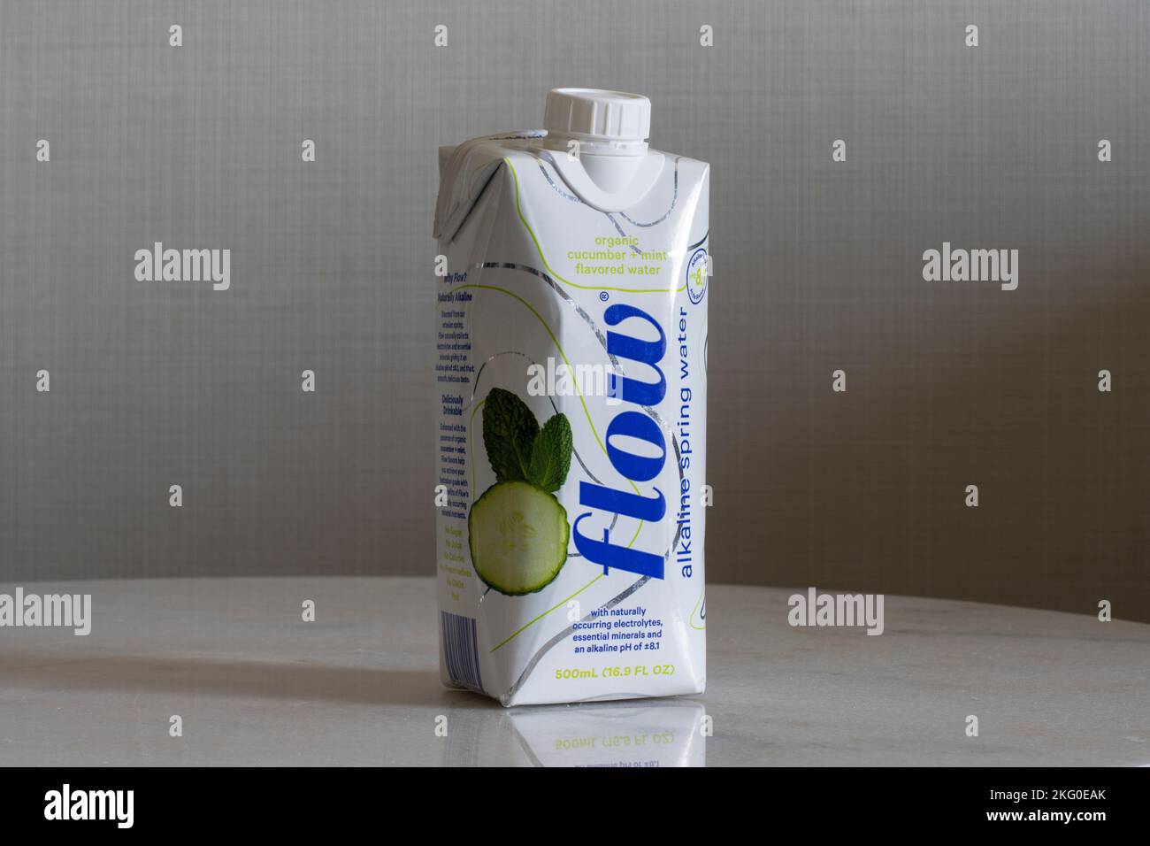 Une bouteille d'eau de source alcaline au goût de concombre à la menthe isolée sur une table basse. Flow est une entreprise d'eau de qualité à croissance rapide basée dans ... Banque D'Images