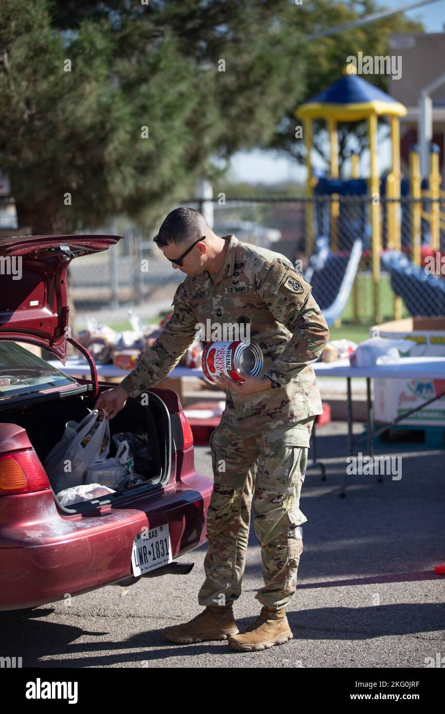 Sergent-chef de l'armée américaine Ryan Joseph, étudiant à l'académie des sergents Majors à fort Bliss, aide à charger de la nourriture dans le coffre d'une voiture pendant la campagne alimentaire de l'Association chrétienne des jeunes hommes des Forces armées à El Paso, Texas, 19 octobre 2022. Les bénévoles qui participent à la production alimentaire contribuent à faire passer plus de 3 000 kg de nourriture chaque mercredi. Banque D'Images