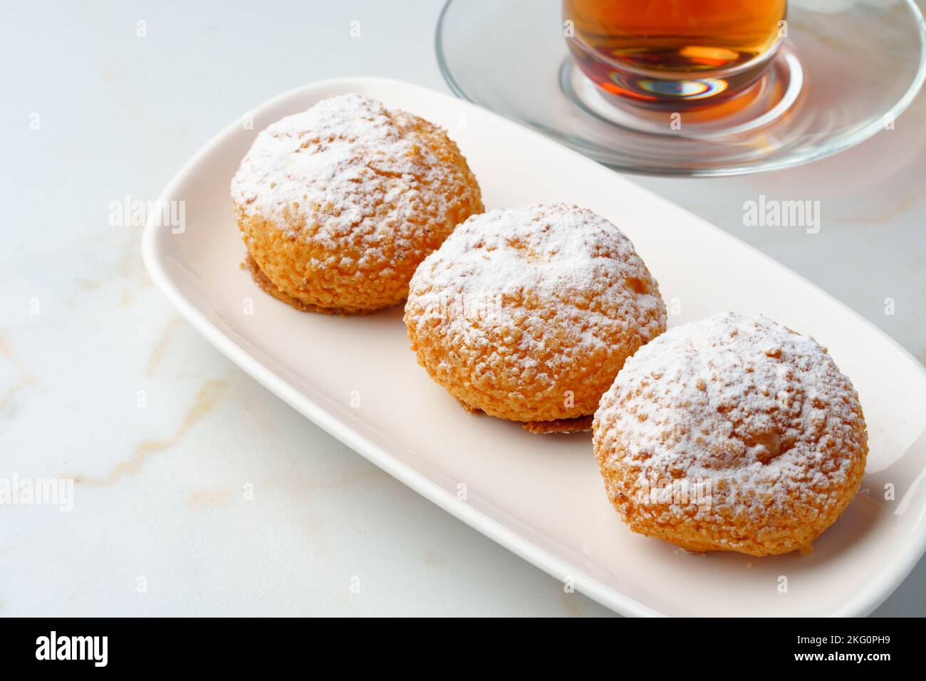 Profiteroles maison avec sucre en poudre sur plaque blanche Banque D'Images