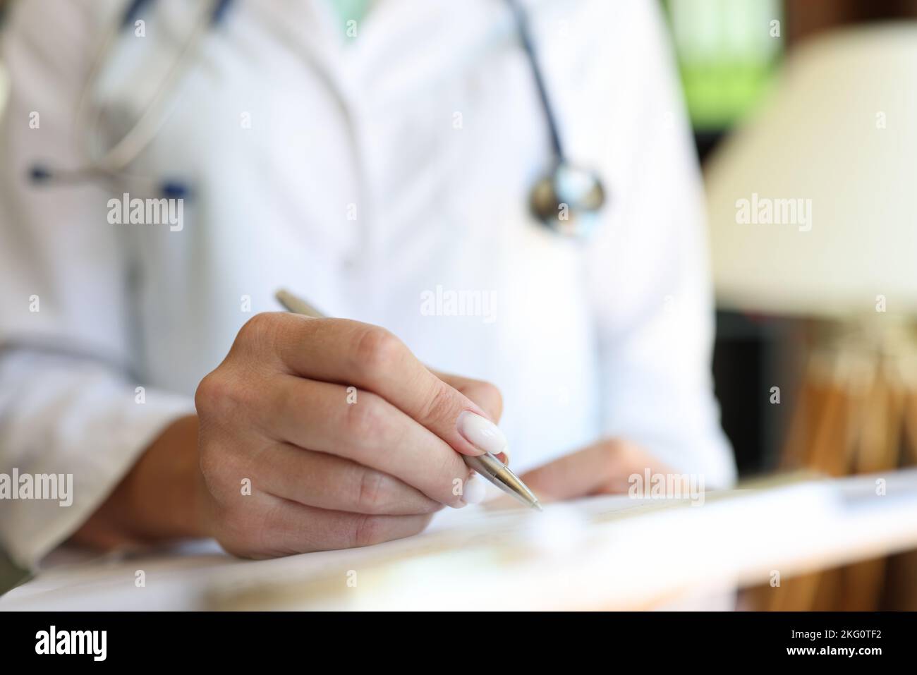 Médecin dans une blouse médicale mettre l'affiche sur le presse-papiers avec des documents Banque D'Images