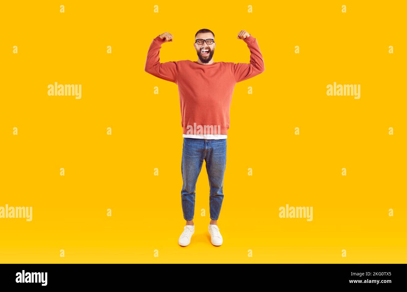 Taille basse portant un pull-over décontracté montrant les bras muscles souriant fier. Banque D'Images