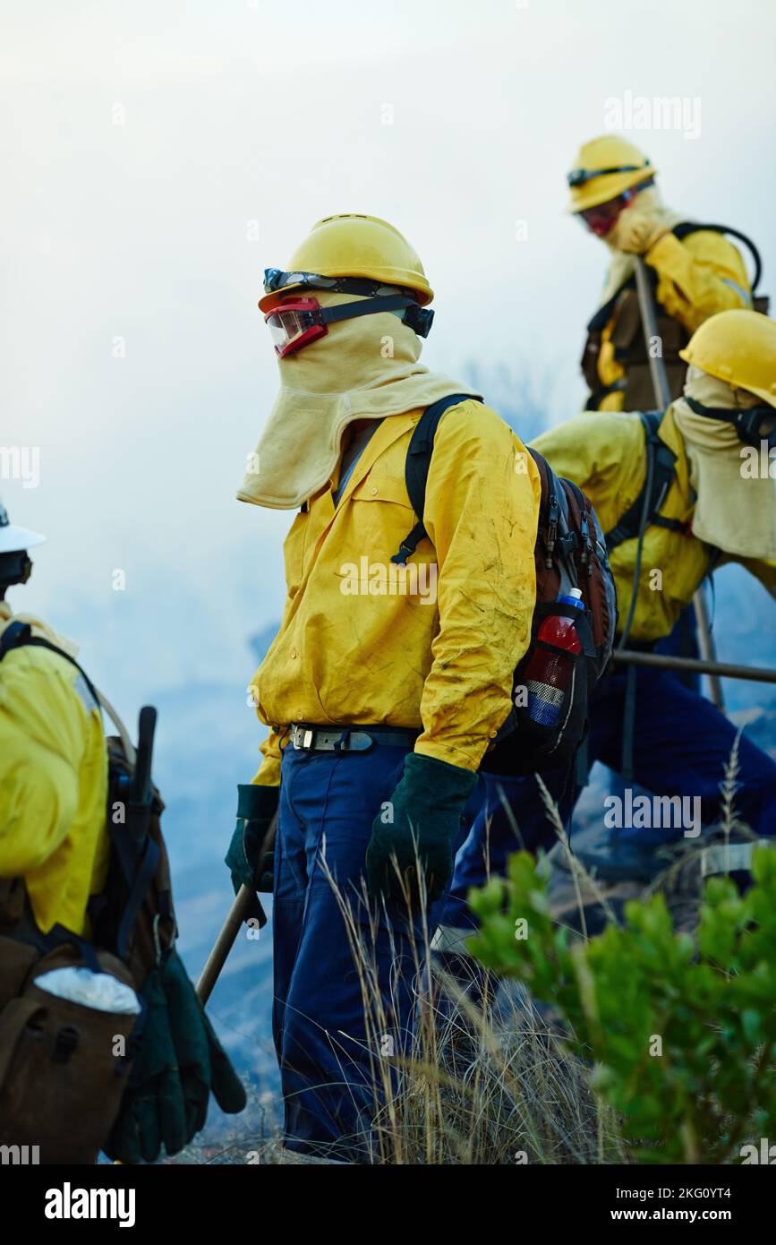 Prêt à prendre le combat jusqu'au feu. Pompiers combattant un feu sauvage. Banque D'Images