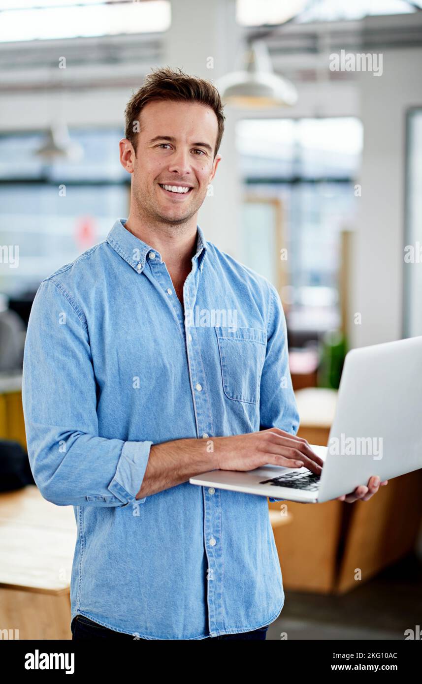 Une entreprise innovante. Un homme travaillant sur un ordinateur portable dans un bureau. Banque D'Images