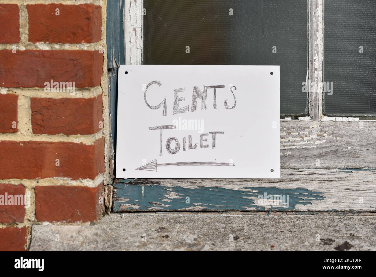 Panneau écrit à la main hâtivement menant aux toilettes de gents Banque D'Images