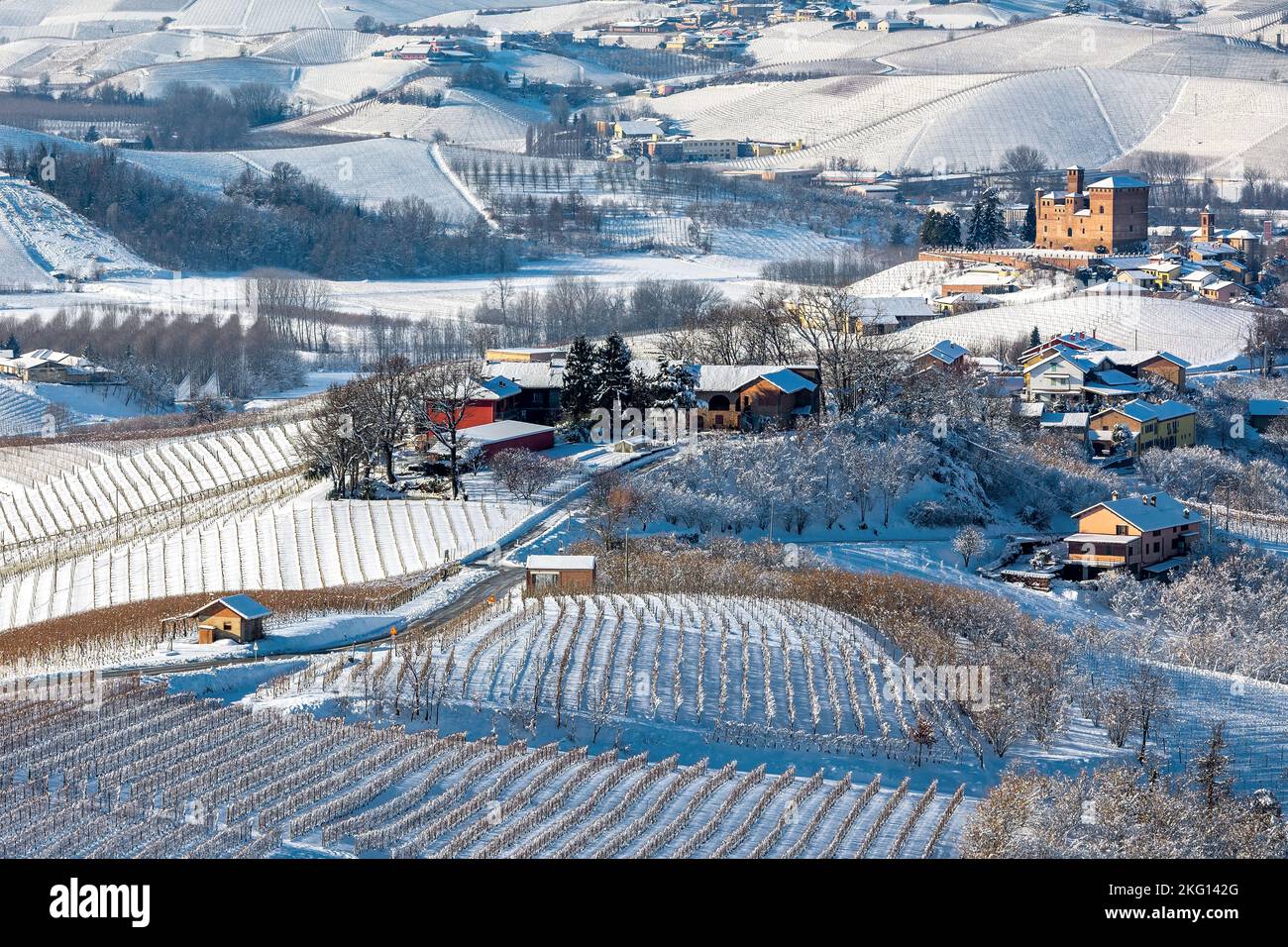Vue de dessus du petit village parmi les collines et les vignobles couverts de neige dans le Piémont, dans le nord de l'Italie. Banque D'Images