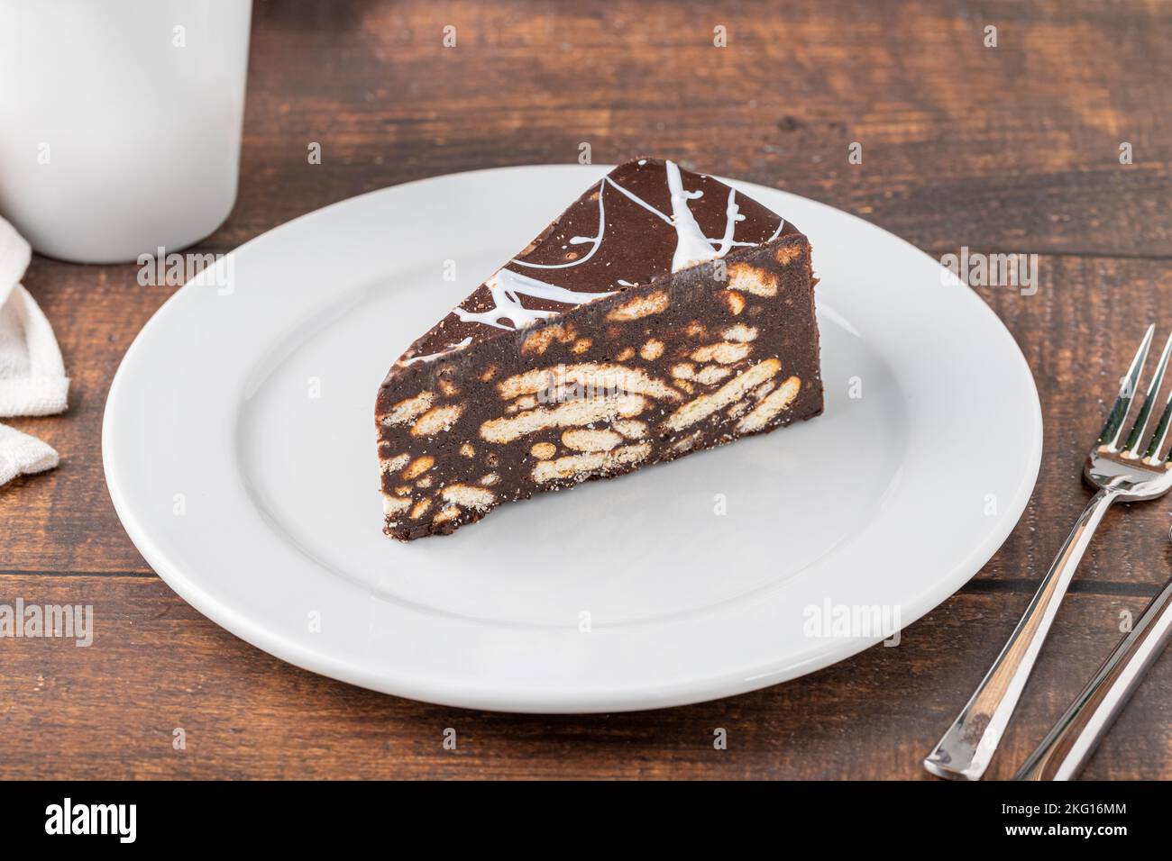 Gâteau en mosaïque de chocolat sur une assiette en porcelaine blanche avec du café filtre sur le côté Banque D'Images