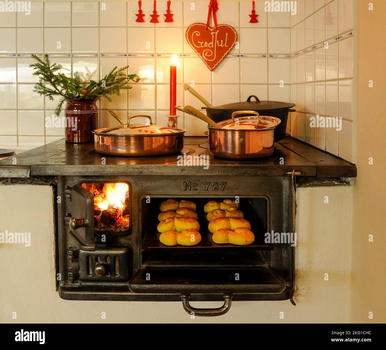 Cuisinière suédoise avec des petits pains au safran dans le four à l'heure de noël Banque D'Images