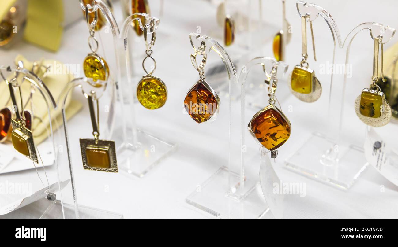 Des boucles d'oreilles avec de l'ambre naturel sont sur le comptoir, photo de gros plan avec une mise au point douce sélective Banque D'Images