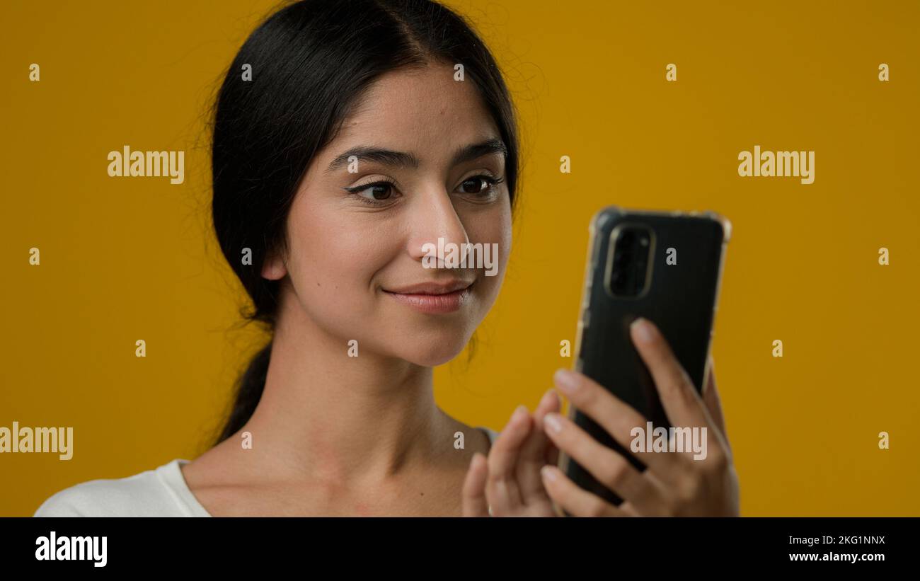 Gros plan portrait en studio Indian ethnique 20s femme fille femme dame regardant l'écran de smartphone navigation dactylographiant recherche de chat dans Internet Banque D'Images