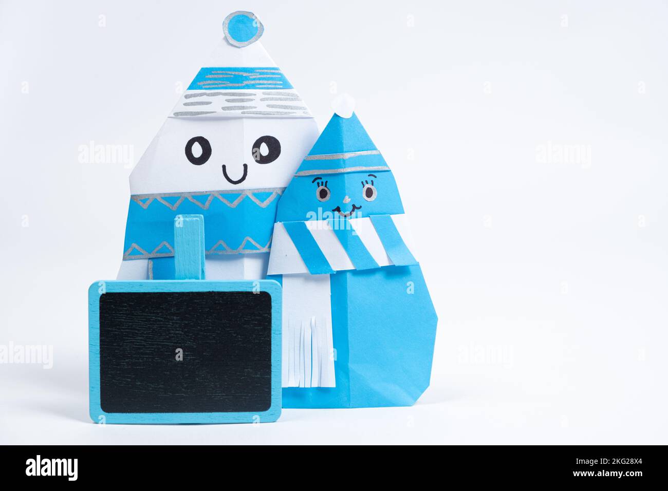 Deux bonhommes de neige en papier origami, lieu pour le texte. Artisanat pour Noël et le nouvel an. Banque D'Images