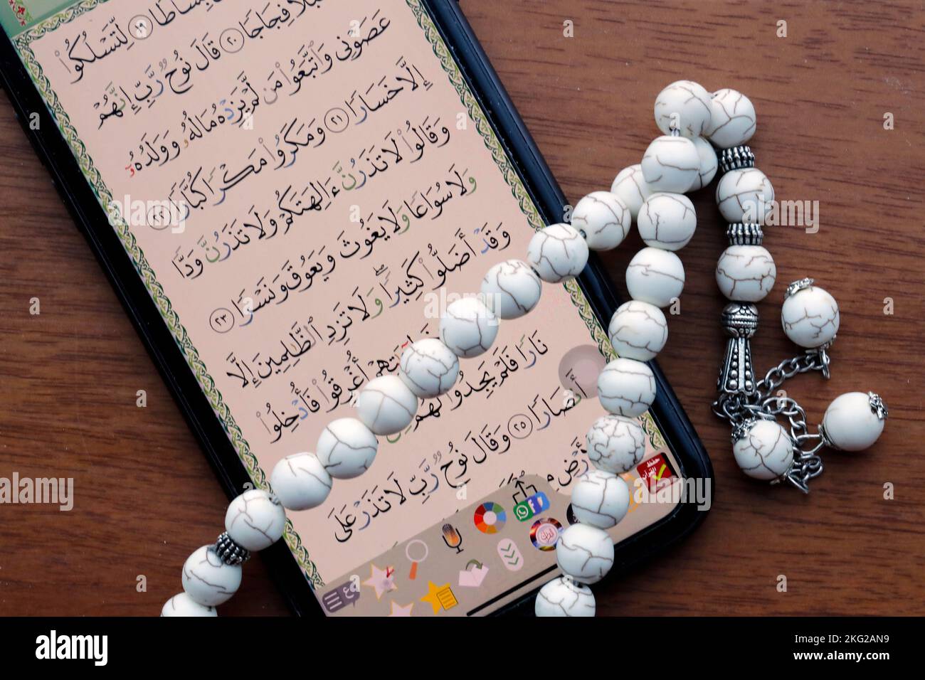 Coran numérique sur un smartphone et perles de prière musulmanes. Coran numérique sur une tablette et Coran traditionnel sur papier. Banque D'Images