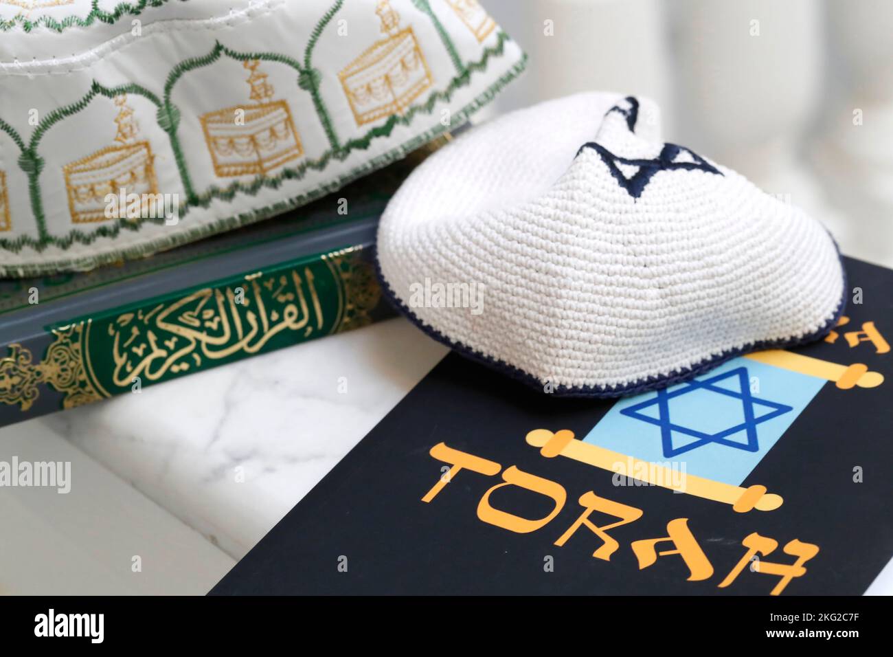 Symboles religieux : le chapeau Kufi musulman avec le Coran, et le Kippah  juif avec la Torah. Concept de dialogue interreligieux ou interreligieux  Photo Stock - Alamy