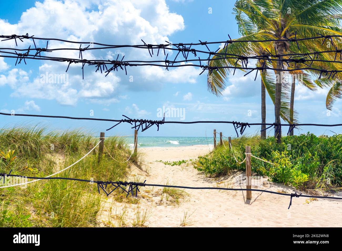 Vue à travers le barbelé jusqu'à Sand Path en direction de l'océan à Miami Beach, Floride Banque D'Images